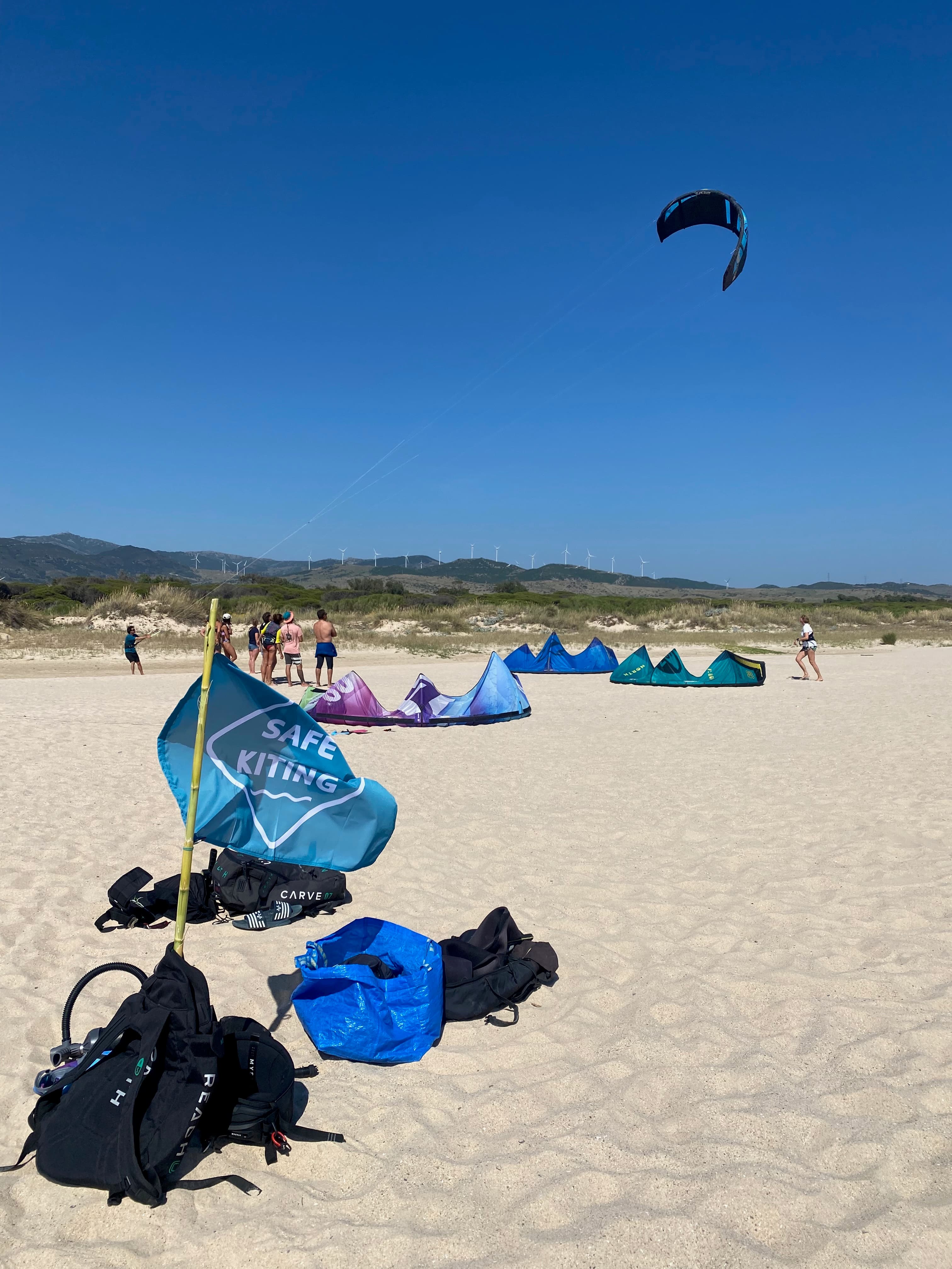 Safe Kiting flag and participants flying a kite on the beach